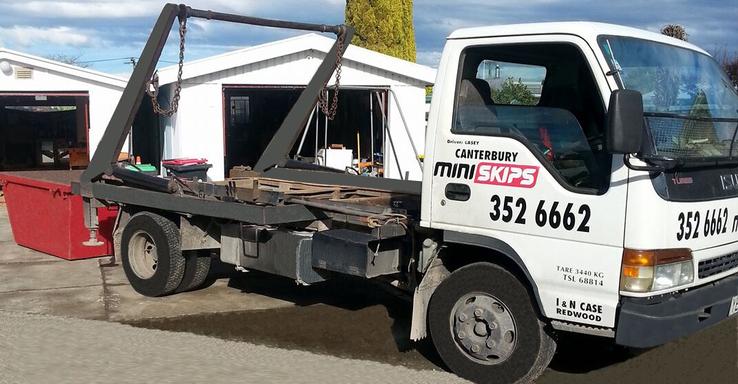 The Canterbury Mini Skips hook-lift truck at the Redwood yard with the company logo on the driver door