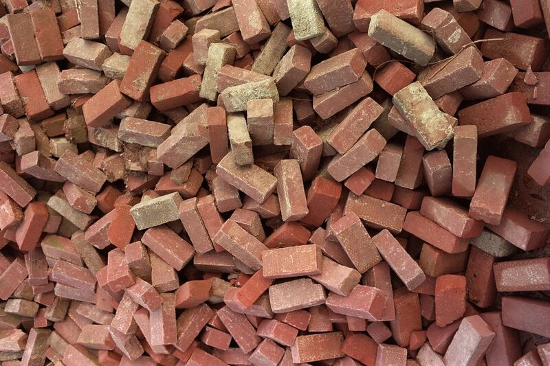A heap of broken red bricks and brick offcuts filling the frame