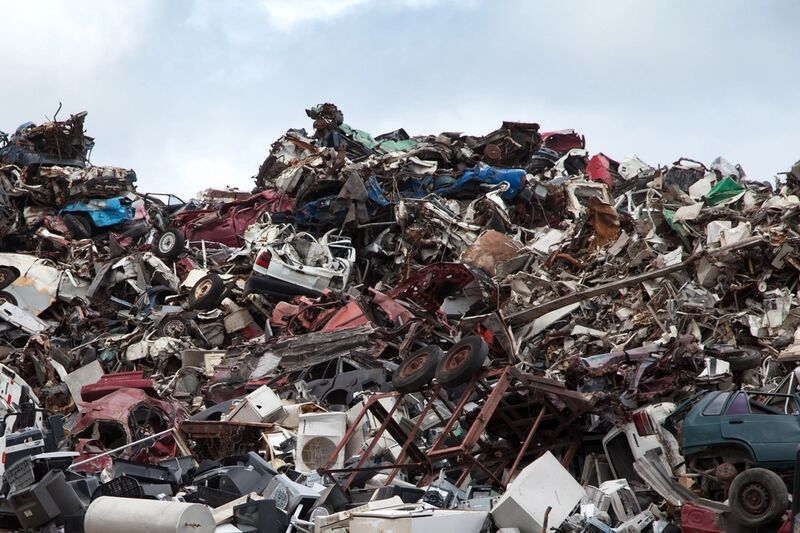 A large mixed pile of non-hazardous bulk waste including scrap metal, timber and household junk